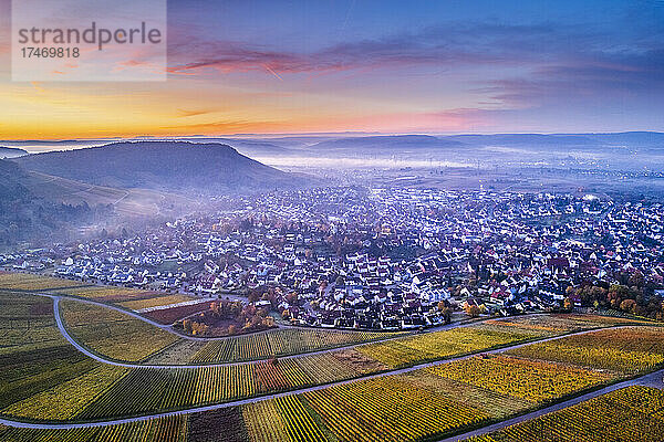 Deutschland  Baden-Württemberg  Korb  Drohnenansicht der Weinberge und der umliegenden Stadt bei nebliger Herbstdämmerung