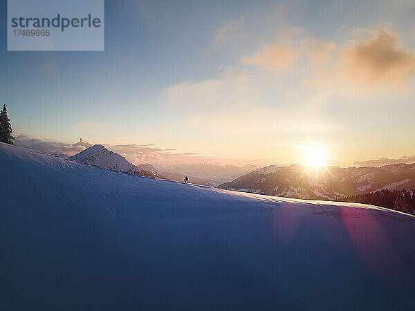 Frau beim Skifahren am schneebedeckten Berghang bei Sonnenaufgang  Schonkahler  Tirol  Österreich