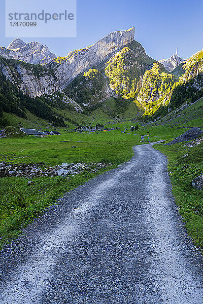 Leere unbefestigte Straße  die sich im Morgengrauen durch das Tal im Alpsteinmassiv erstreckt