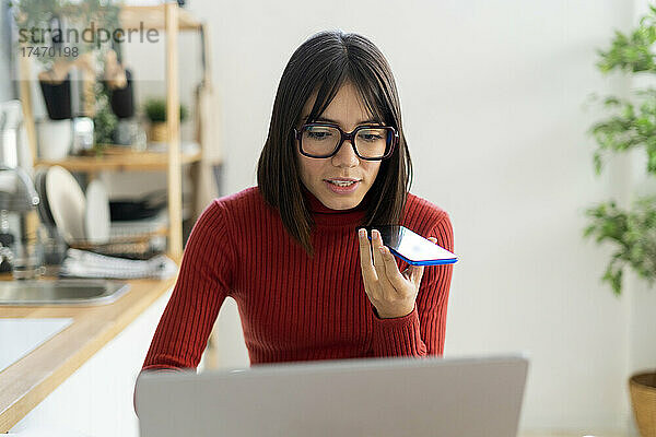 Geschäftsfrau benutzt Laptop und telefoniert im Heimbüro