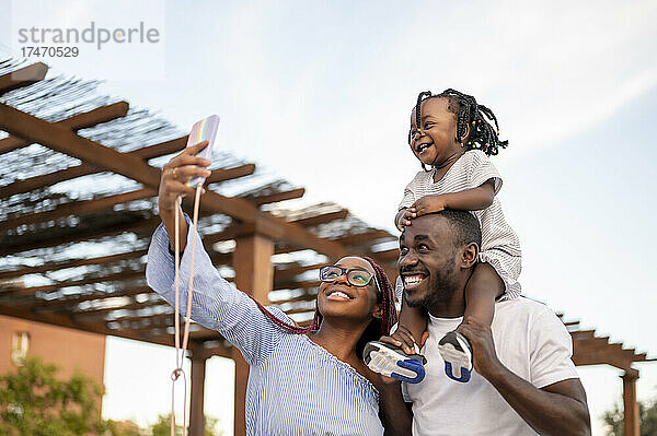 Frau macht Selfie mit Familie beim Dachdecker