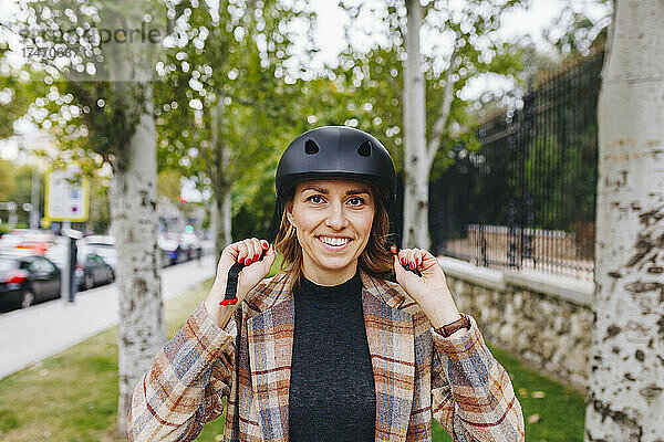 Lächelnder Freiberufler mit Helm vor dem Park