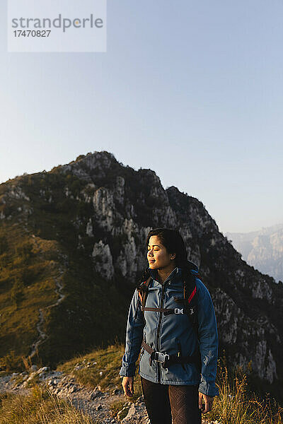 Junge Frau mit geschlossenen Augen auf dem Berg