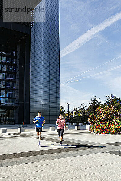Männliche und weibliche Sportler üben beim Laufen in der Stadt