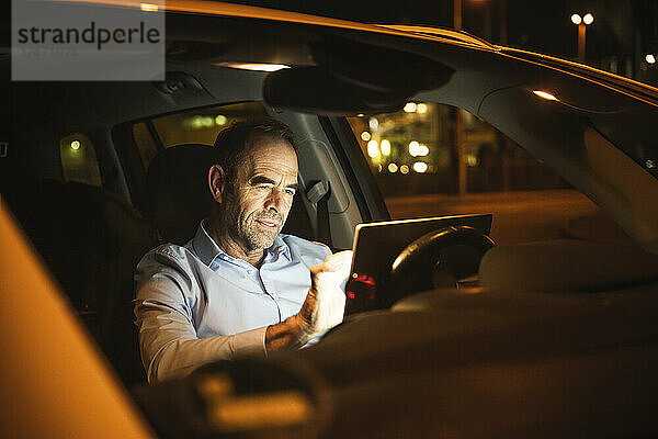 Geschäftsmann benutzt nachts Laptop im Auto