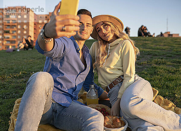 Freund macht Selfie mit Freundin per Smartphone auf Hügel