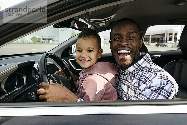 Fröhlicher Vater und Sohn spielen im Auto