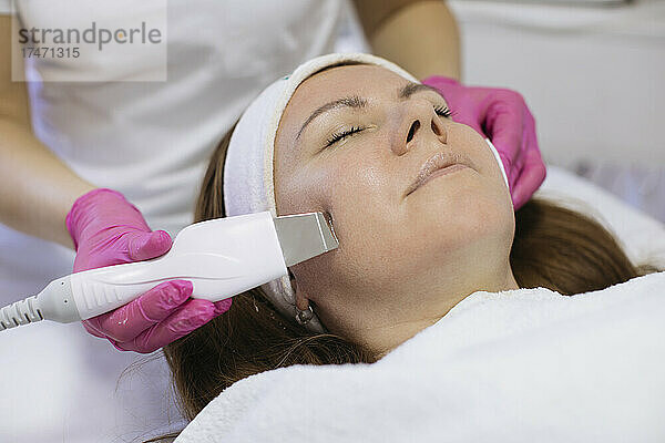 Frau nimmt Ultraschall-Gesichtsbehandlung im Salon