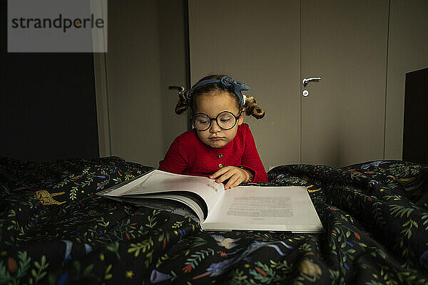 Nettes Mädchen liest Buch im Schlafzimmer
