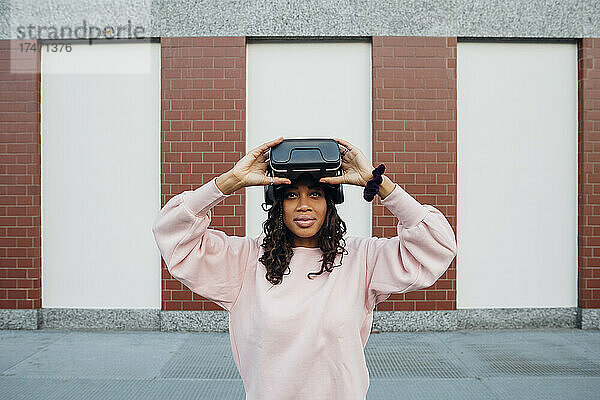 Frau hält Virtual-Reality-Headset auf Fußweg