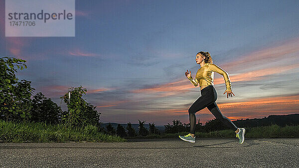 Junge Frau joggt allein in der Abenddämmerung