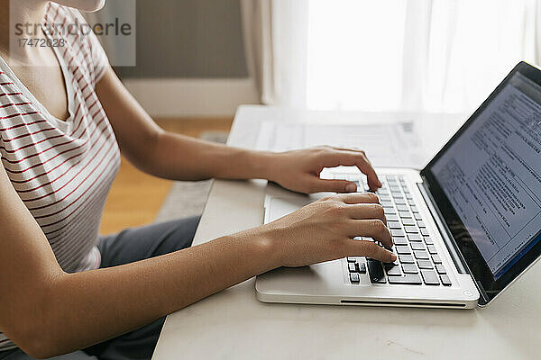 Berufstätige Frau benutzt Laptop zu Hause