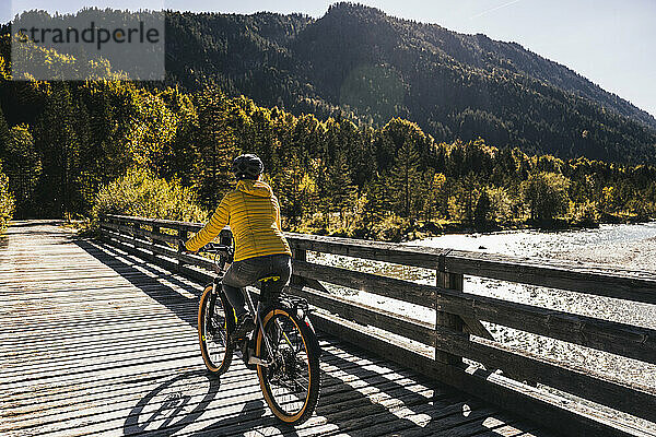 Frau fährt Mountainbike auf Brücke