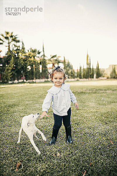 Lächelndes Mädchen mit Hund steht auf der Ranch