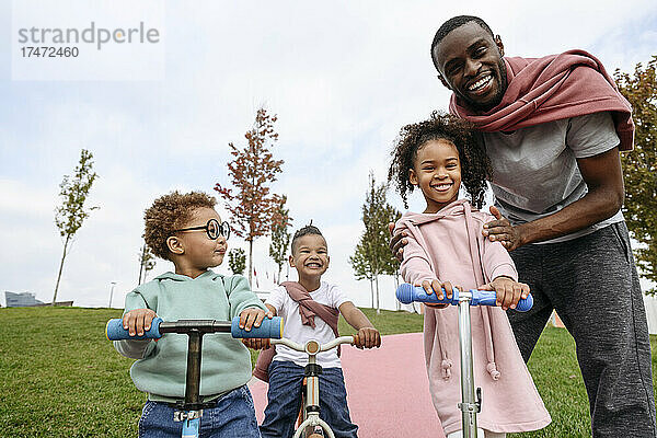 Glückliche Kinder stehen mit Vater im Park