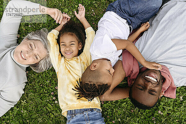 Lächelnde Familie  die zusammen auf Gras ruht