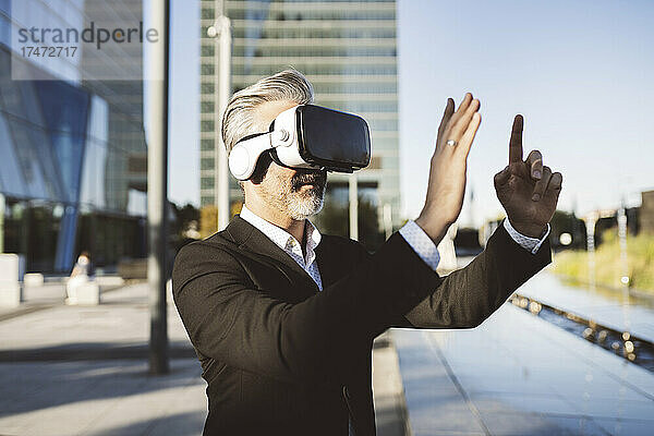 Geschäftsmann gestikuliert mit Virtual-Reality-Headset
