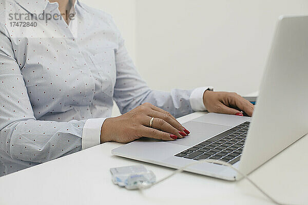 Geschäftsfrau sitzt am Schreibtisch und arbeitet im Heimbüro am Laptop