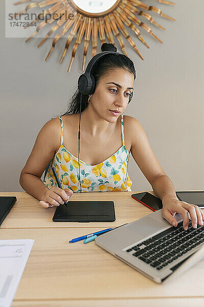 Junge Geschäftsfrau arbeitet zu Hause am Laptop