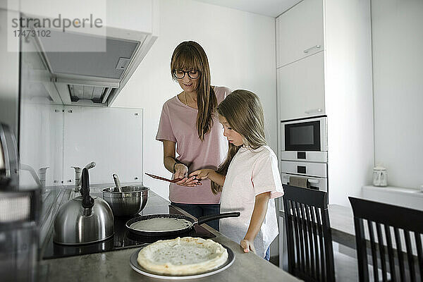 Tochter lernt von Mutter in der Küche kochen