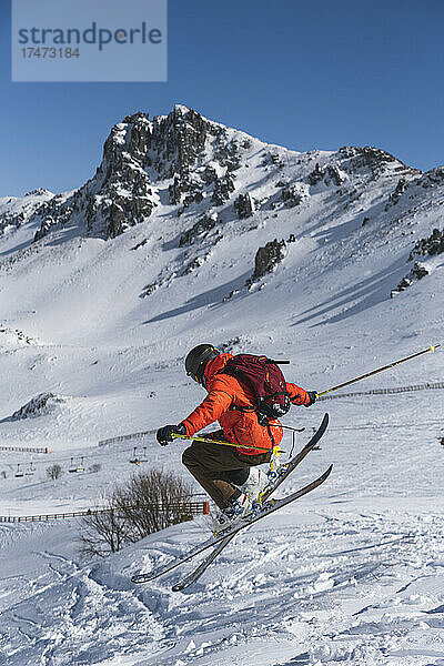 Tourist mit Rucksack beim Skifahren auf schneebedecktem Berg