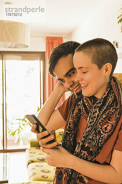 Paar teilt Smartphone im Wohnzimmer