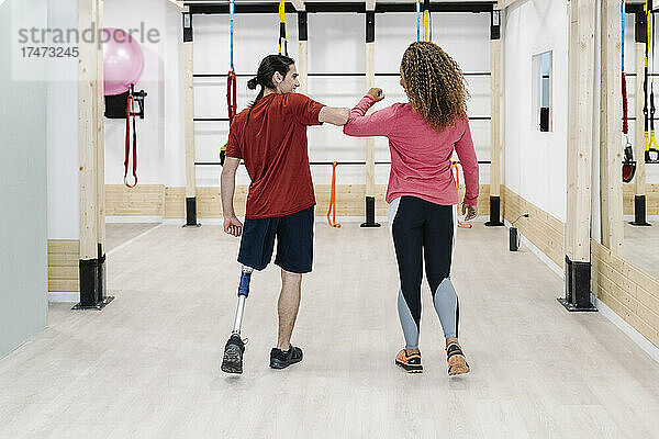 Behinderter Sportler macht Ellenbogenstoß mit Freund im Fitnessstudio