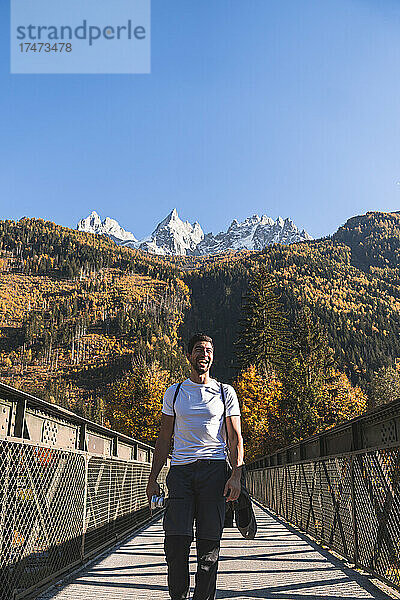 Wanderer  der an einem sonnigen Tag auf einer Fußgängerbrücke vor den französischen Alpen spaziert  Chamonix  Frankreich