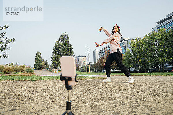 Frau filmt Tanz mit Handy im Park
