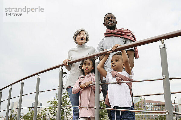 Vater und Großmutter stehen mit Kindern am Geländer