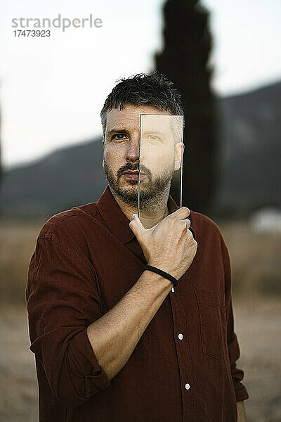 Mann schaut durch ein transparentes Glasstück