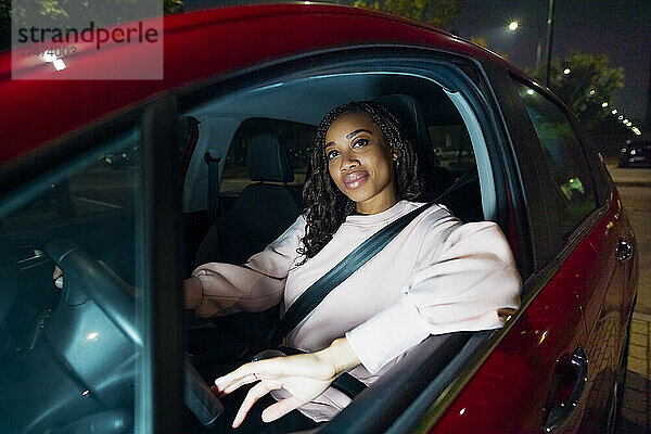 Lächelnde junge Frau  die Auto fährt