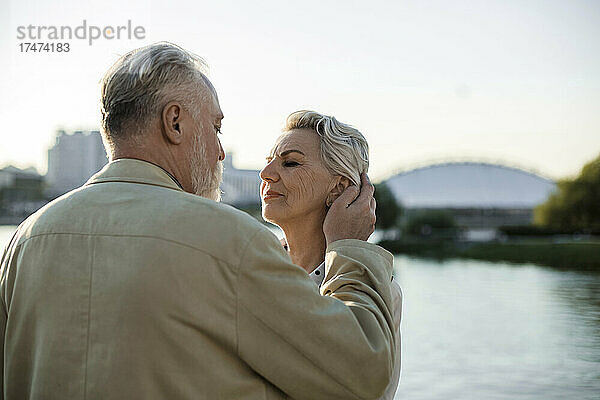 Mann schaut ältere Frau bei Sonnenuntergang an