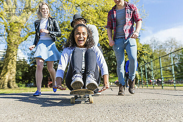 Junge Frau spielt mit Freunden im Park