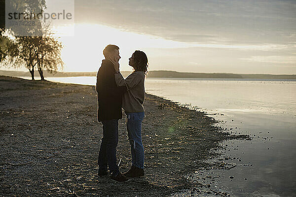 Romantisches Paar steht am Seeufer