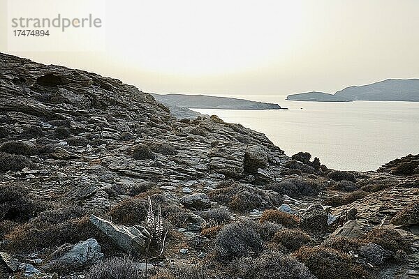 Küste von Tinos an der engsten Stelle zu Andros im ungewöhnlich weißen Sonnenuntergangslicht. Tinos  Kykladen  Griechenland  Europa