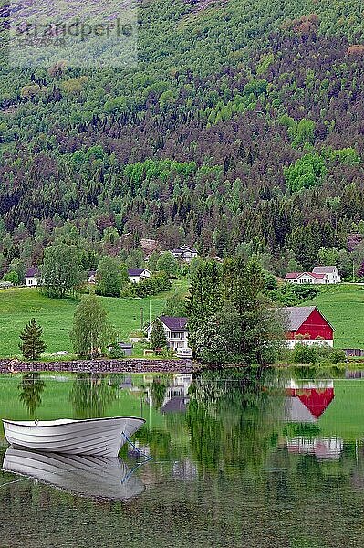 Boote und Häuser spiegeln sich im seichten Wasser eines Sees  Stryn  Skandinavien  Norwegen  Europa