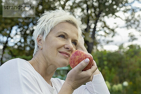Frau isst frischen roten Apfel