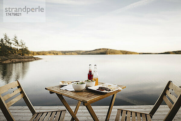 Essen auf dem Tisch am See gegen den Himmel angeordnet