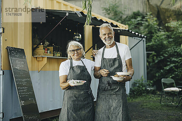 Porträt eines älteren Mannes und einer Frau mit Essen im Park