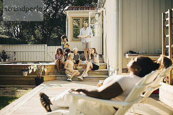 Familie verbringt Freizeit auf der Terrasse an einem sonnigen Tag