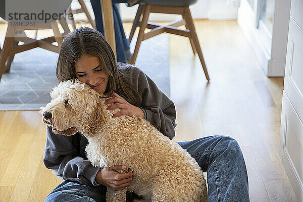Mädchen umarmt Hund zu Hause