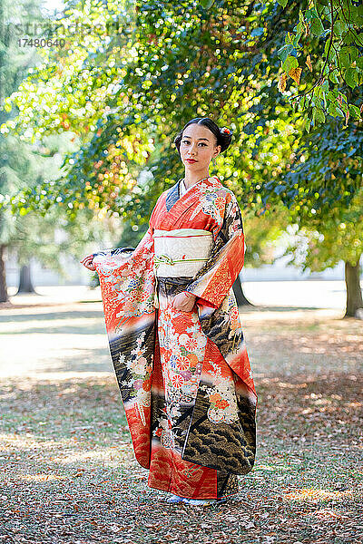 Frau im Kimono posiert im Park