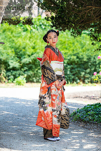 Porträt einer Frau im Kimono  die im Park steht