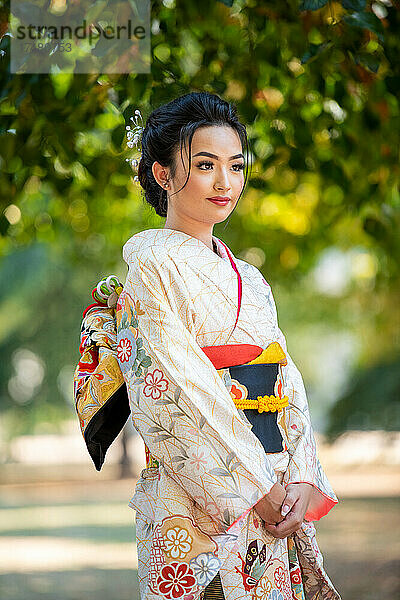 Frau im Kimono steht im Park