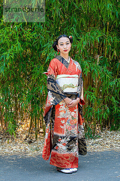 Porträt einer Frau im Kimono  die im Park steht