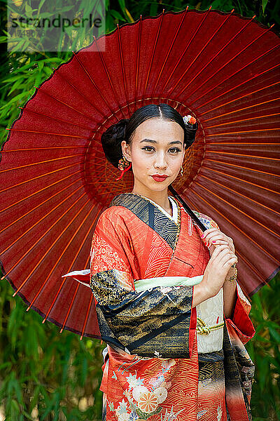 Porträt einer Frau im Kimono und mit Sonnenschirm