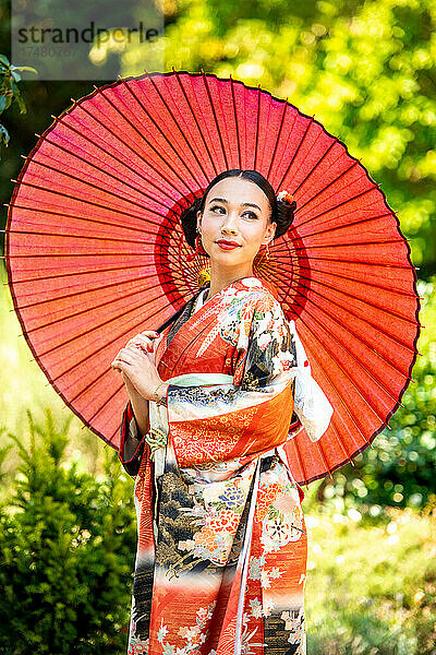 Porträt einer Frau im Kimono mit rotem Sonnenschirm