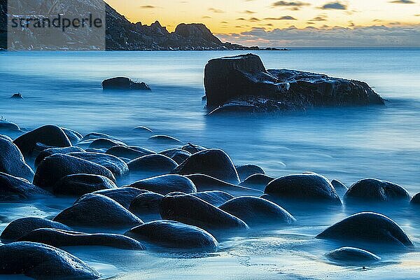 Winterliche skandinavische Landschaft mit stürmischer See  Uttakleiv strand  Meer  Felsen  blaue Stunde  Langzeitbelichtung  Leknes  Nordland  Lofoten  Norwegen  Europa