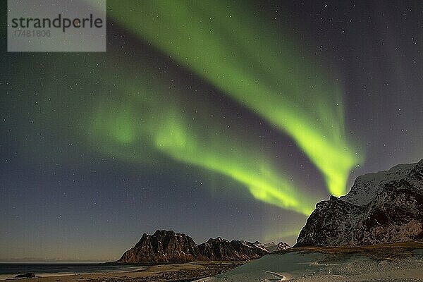 Polarlicht in winterlicher skandinavische Landschaft  Nordlicht (Aurora borealis) Meer  Berge  Sterne  Uttakleiv strand  Leknes  Nordland  Lofoten  Norwegen  Europa
